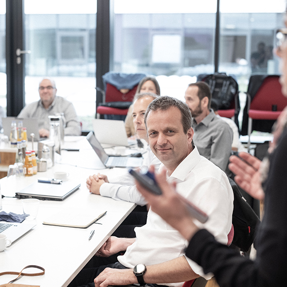 Eine Gruppe von Menschen arbeiten mit Laptops zusammen