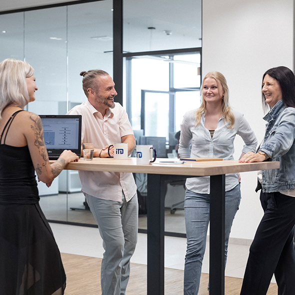 A diverse group of individuals standing around a table, engaged in a discussion